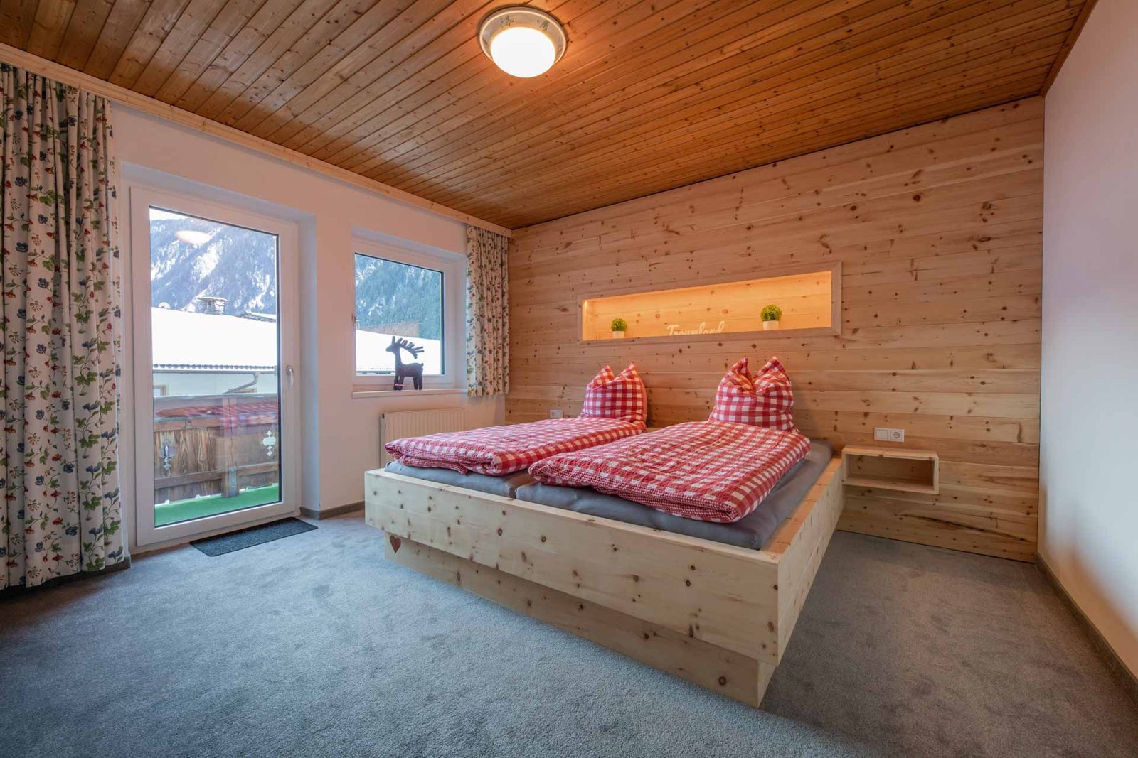 Schlafzimmer mit Zirbenbett und Balkon